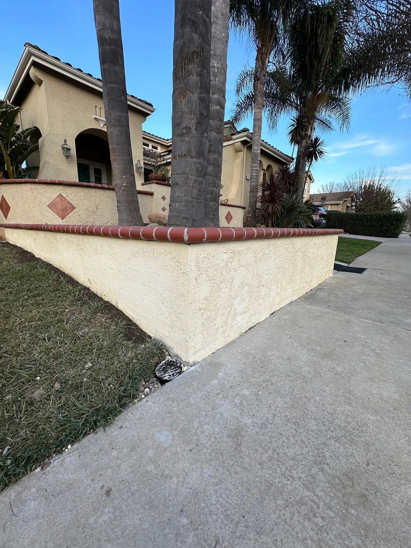 Curved retaining wall beside residential sidewalk