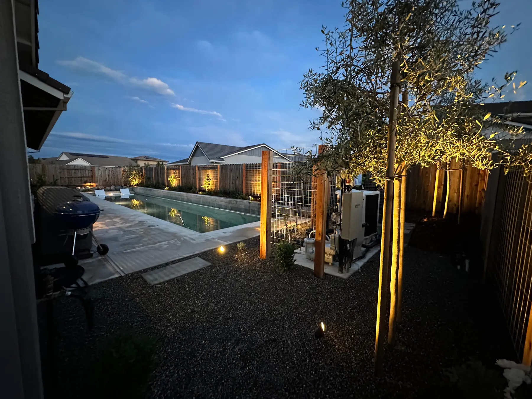 Poolside yard with modern fence lighting and evening sky