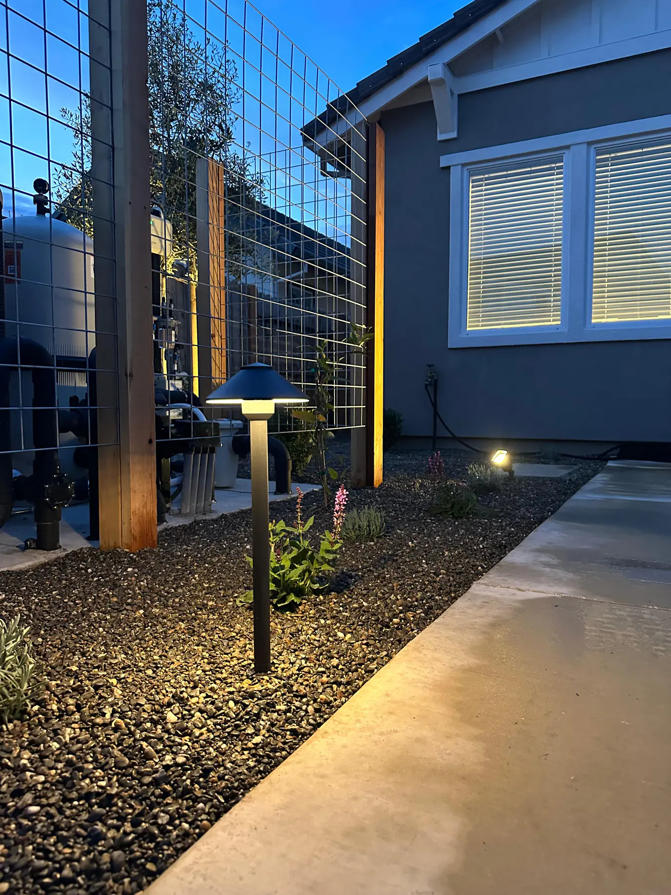 Walkway lighting beside gravel and planting bed